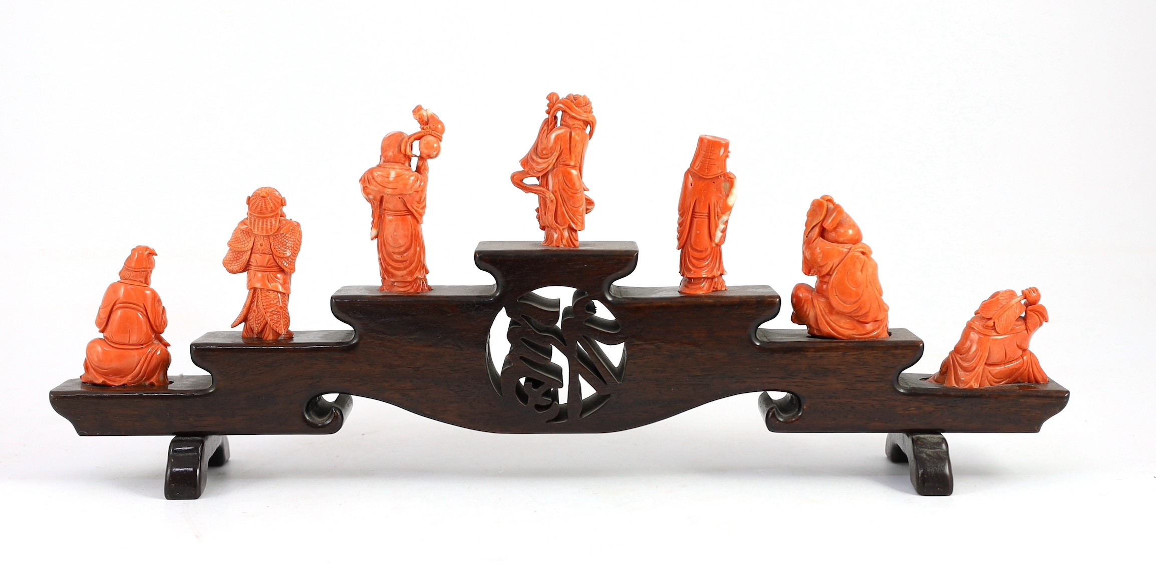 A Chinese or Japanese set of seven coral figures of immortals, 43cm wide, figures 4 to 8cm high